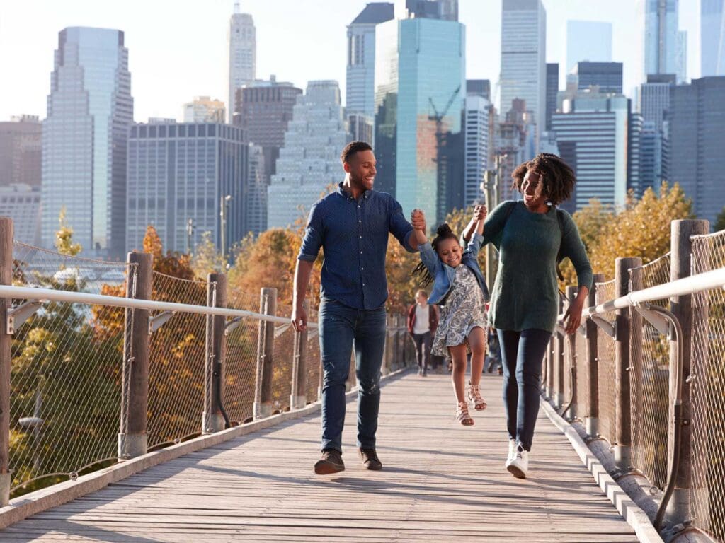 A man and woman walking across a bridge.