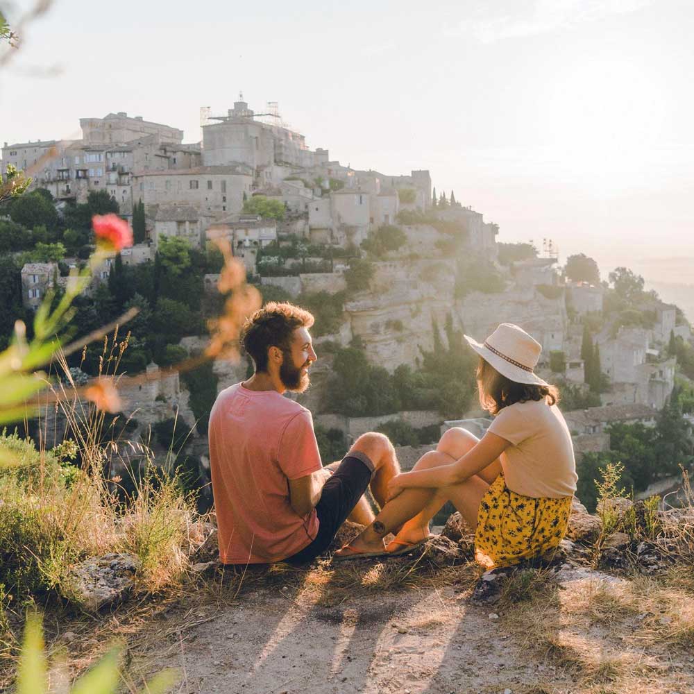 Two people sitting on a hill looking at the town