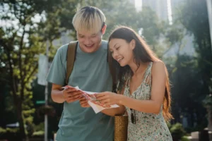 A man and woman looking at papers on the street.