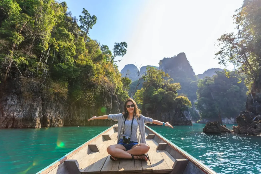 A woman sitting on the back of a boat in the water.