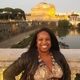 A woman standing in front of a castle.