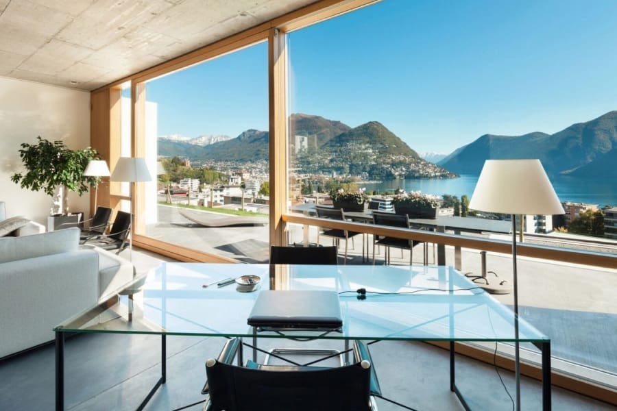 A glass table in front of a large window.