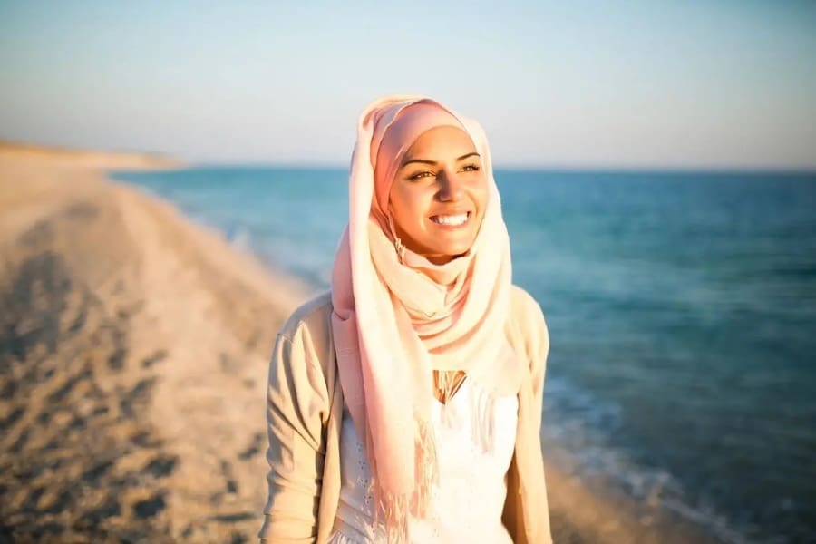 A woman with a pink scarf on the beach