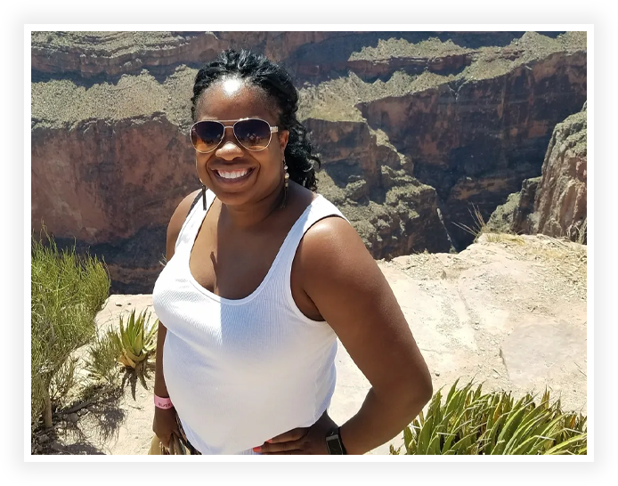 A woman standing on top of a mountain near the edge.